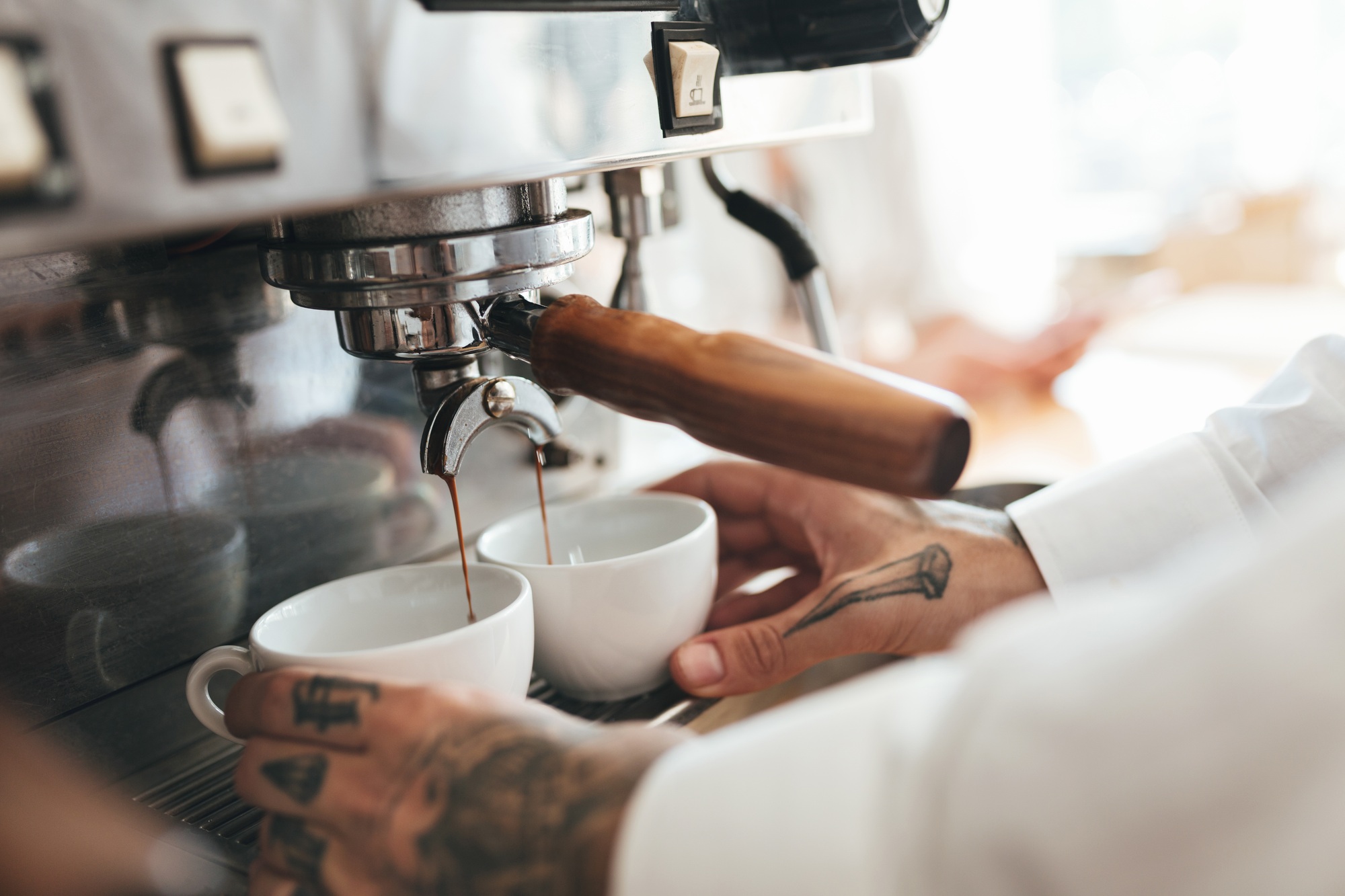 Close up barista hands making coffee by coffee machine in restaurant