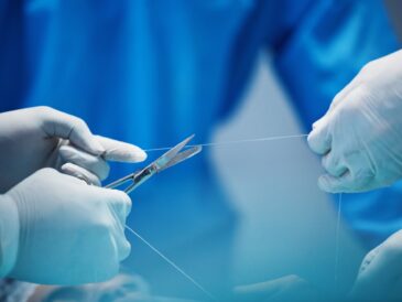Surgery, hands and doctor cut thread, stitching patient and surgical procedure with health insuranc